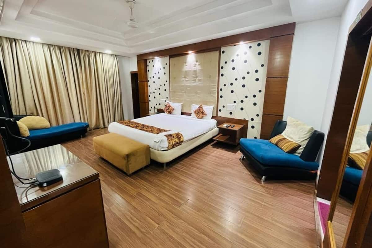 Een hotelkamer met een groot bed, een bank, een bureau en een stoel.