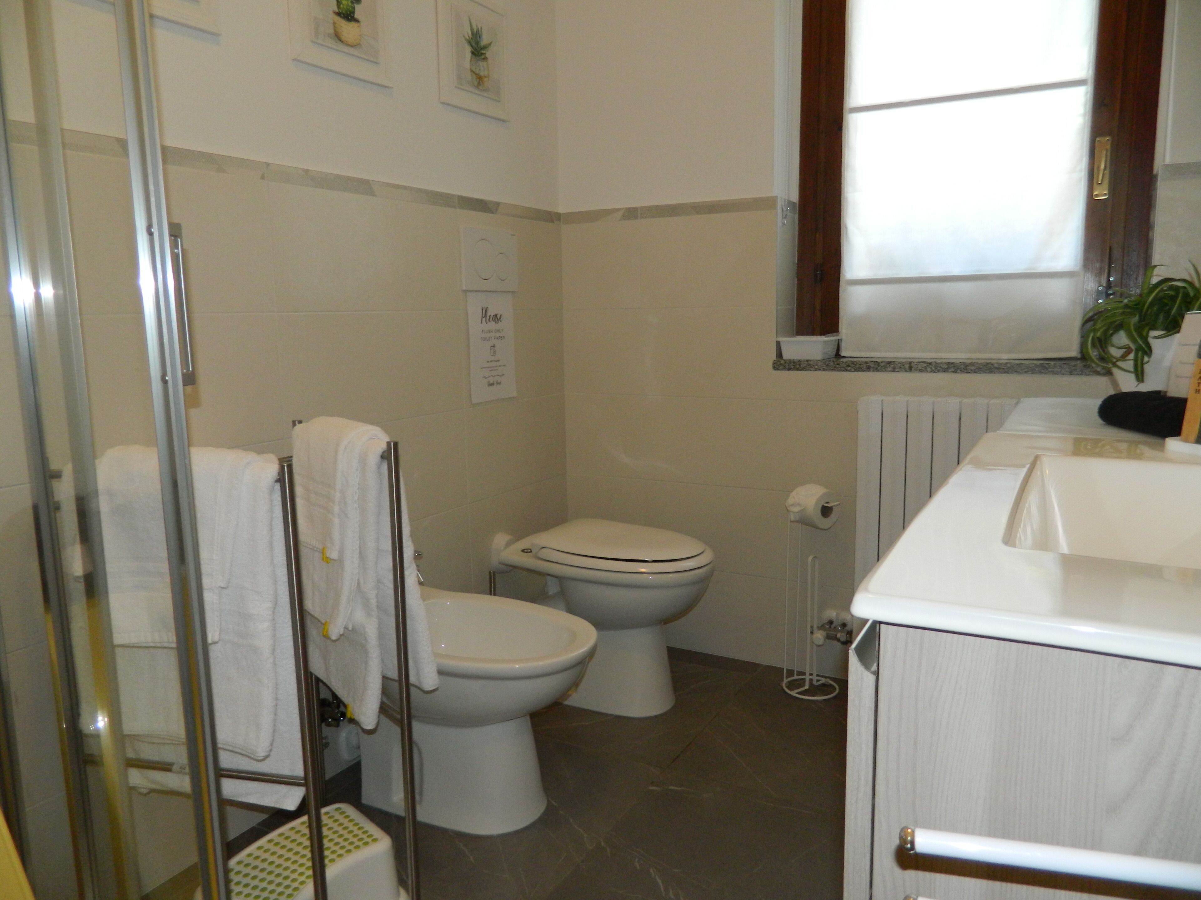 A bathroom with a toilet, a shower, and a sink.