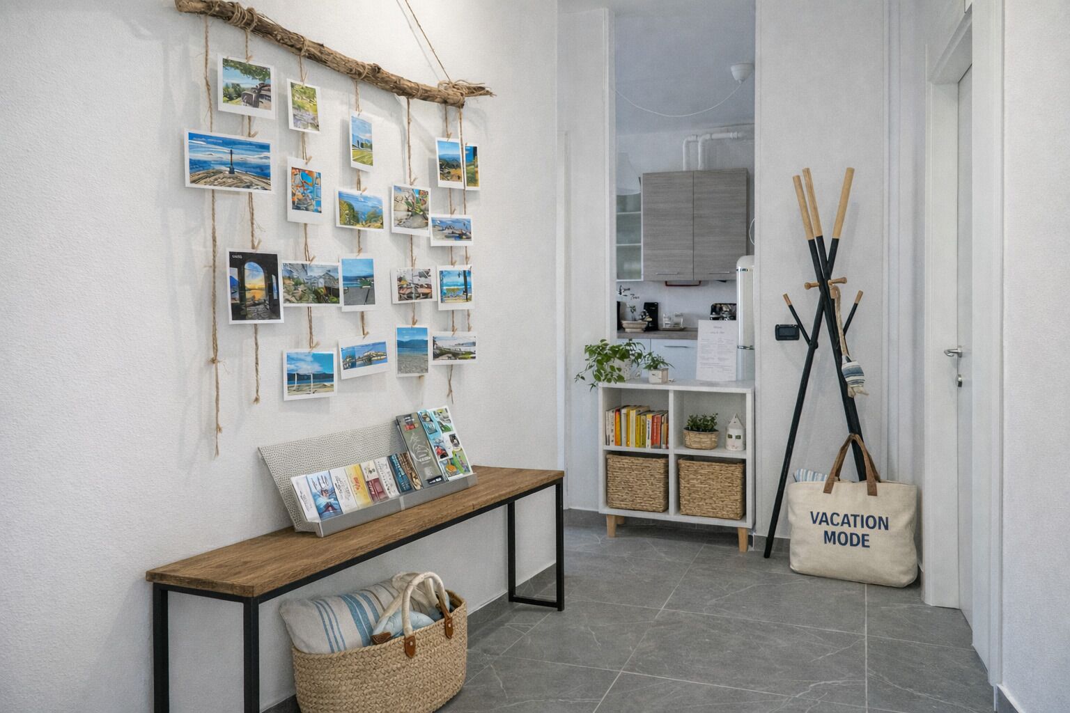 Een gang met een houten bankje, een muur versierd met reisafbeeldingen, een klein boekenrek en een tas met de tekst 'VACATION MODE'.