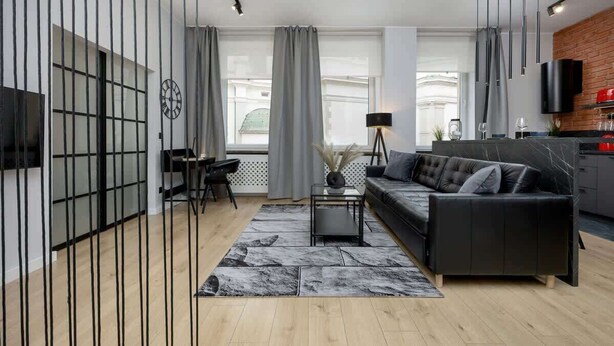 Ein modernes Wohnzimmer mit einer Couch, einem Couchtisch und einem an der Wand montierten Fernseher.