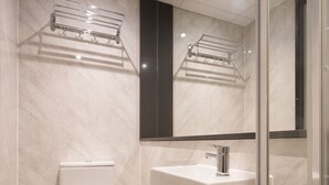 Een moderne badkamer met toilet, wastafel en douchecabine van glas.