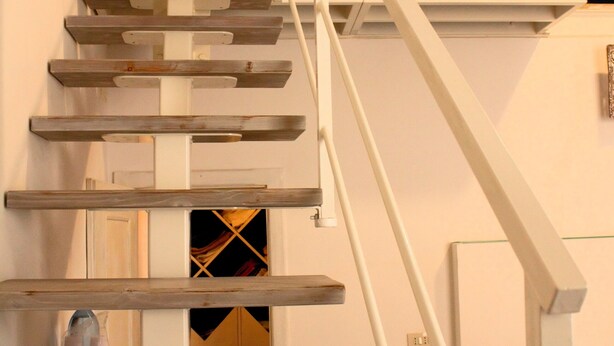 Una scala con ringhiere bianche e gradini in legno.