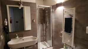 Un bagno moderno con un lavandino ampio, un bidet e un box doccia.