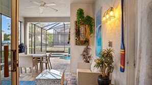 Eine sonnendurchflutete Terrasse mit Pool, Sitzgelegenheiten im Freien und einem Deckenventilator.