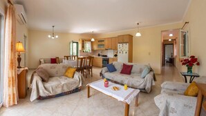 Ein gemütliches Wohnzimmer mit zwei Sofas, einem Esstisch und einer Küche im Hintergrund.