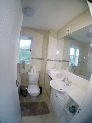 Ein Badezimmer mit Toilette, Waschbecken und Spiegel.