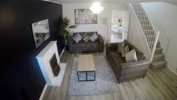 A modern living room with a grey sofa set, a coffee table, and a staircase. - Gorgeous 3 bed in Bristol (Bradley Stoke)