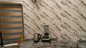 A kitchen with a marble backsplash, a stove, a sink, and a blender on the counter. - Inviting 2-bed Apt With Parking in Ifako-ijaiye (Lagos)
