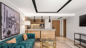 A modern living room with a teal sofa, a glass coffee table, and a large framed picture on the wall. - Radisson Residences Cairo Heliopolis (Cairo)