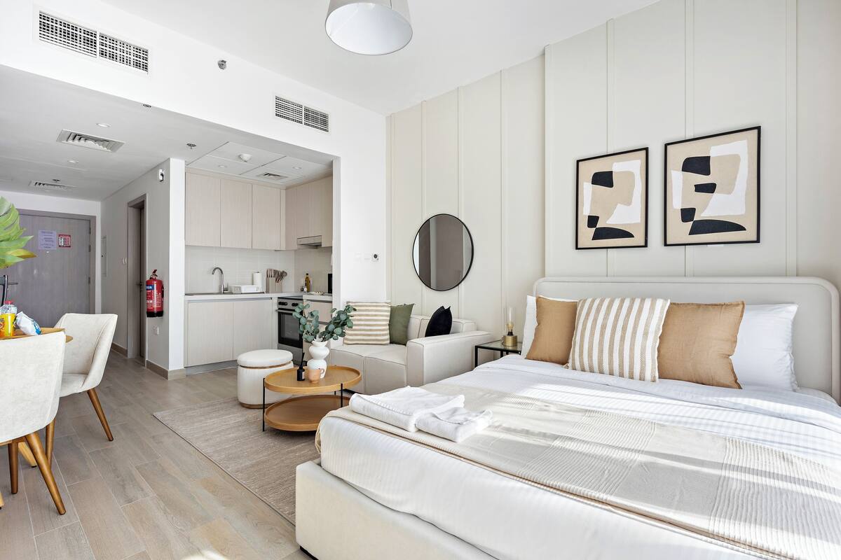 Una habitación de hotel moderna con una cama grande, un comedor y una kitchenette.