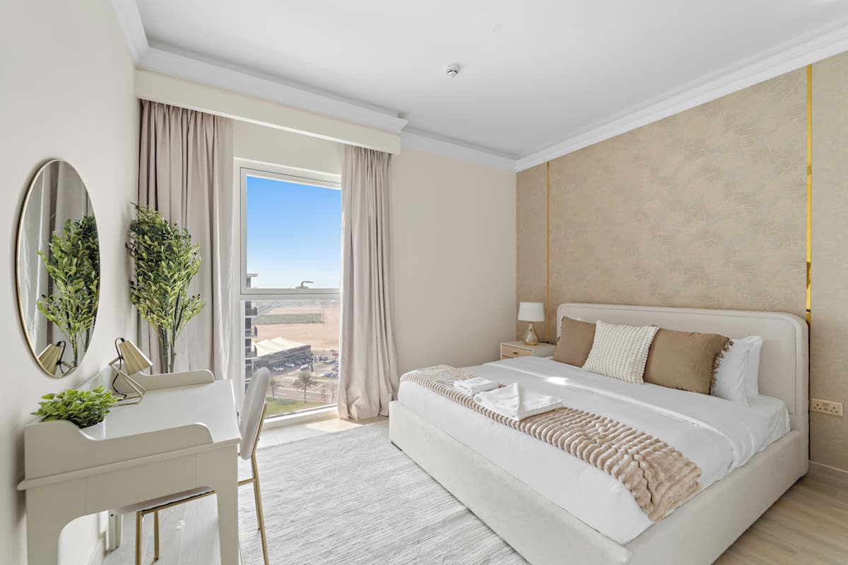 Habitación de hotel moderna con una cama grande, un escritorio y vistas al paisaje desértico.