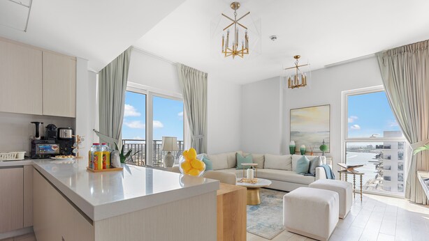 Un apartamento moderno con cocina, sala de estar y ventanas grandes que ofrecen vistas a la ciudad.