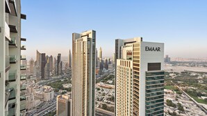 Un edificio de gran altura con el nombre 'EMAAR' en su fachada, rodeado de otros edificios altos y un paisaje urbano.