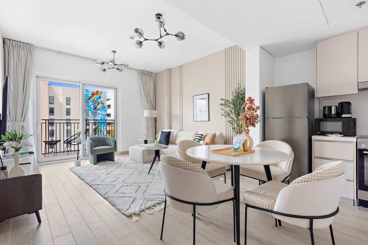 Una sala de estar moderna con comedor, cocina y balcón con vistas a la ciudad.