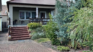 A two-story house with a tiled roof, a front porch, and a brick pathway leading to the entrance. - Ferienhaus Oma Inge Zwischen Goitzsche und Muldestausee Haustierfreundlich ! (Muldestausee)
