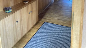 A wooden interior with a mirror, a small sink, and a blue mat on the floor. - Ferienhaus Oma Inge Zwischen Goitzsche und Muldestausee Haustierfreundlich ! (Muldestausee)