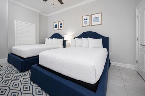 A hotel room with two beds, a patterned rug, and framed artwork on the wall. - Phoenix Gulf Towers 901 4 Bedroom Condo (Orange Beach)