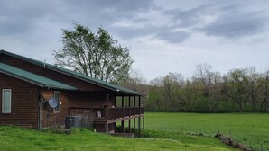 Eine Holzhütte mit Veranda und einem umzäunten Garten.