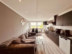 A modern kitchen with a dining area, a sofa, and a view of the outdoors. - 90 I Sauna I 7 Beds I To the beautiful view (Dortmund)