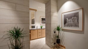A modern kitchen with wooden cabinets, a countertop, and two potted plants. - Ripetta Luxury Apartments (Rome)