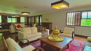 A spacious living room with a large window, a white sofa, a wooden coffee table, and a patterned rug. - Casa Iracema da Serra (Vale do Paquequer)
