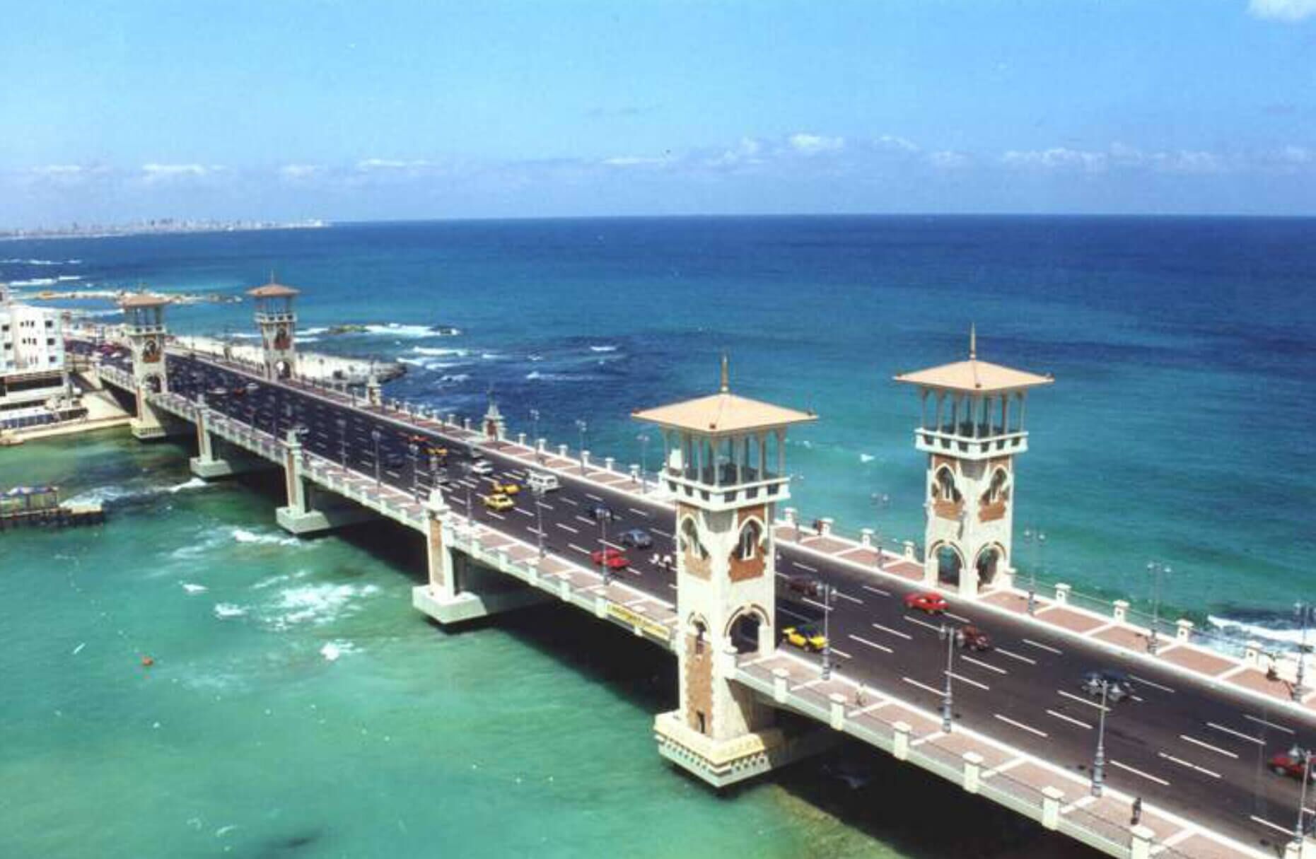 Un puente extenso con dos torres que une dos extensiones de tierra sobre el agua.