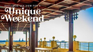 An outdoor dining area with wicker furniture and a view of the sea. - Amwaj Hotel (Alexandria)