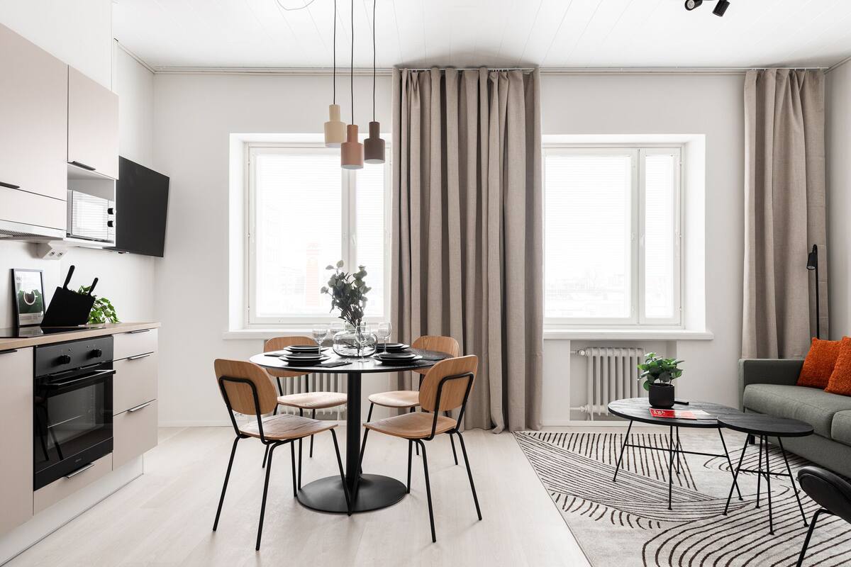 Eine moderne Küche mit Essbereich, einer Couch und einem kleinen Tisch mit Pflanze.