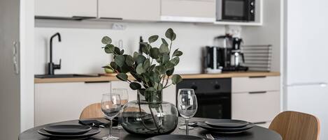 Una cocina moderna con armarios blancos, microondas y cafetera.