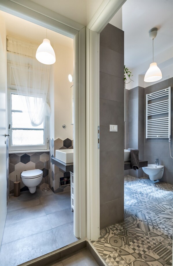 A modern bathroom with a toilet, sink, and shower area.