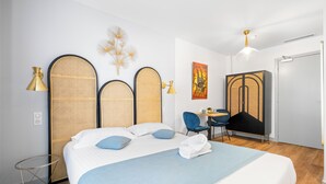 A hotel room with a bed, a desk, a chair, and a wardrobe. - L'App-Art (Nice)