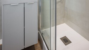 A modern bathroom with a glass-enclosed shower, a white sink, and a mirror above it. - L'App-Art (Nice)