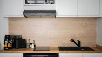 Una cocina moderna equipada con microondas, tostadora, cafetera y lavabo.
