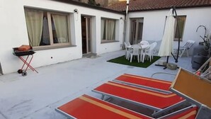 A patio area with a table and chairs, a grill, and a sun lounger. - Casa Aida al Centro di Nurachi (Nurachi)