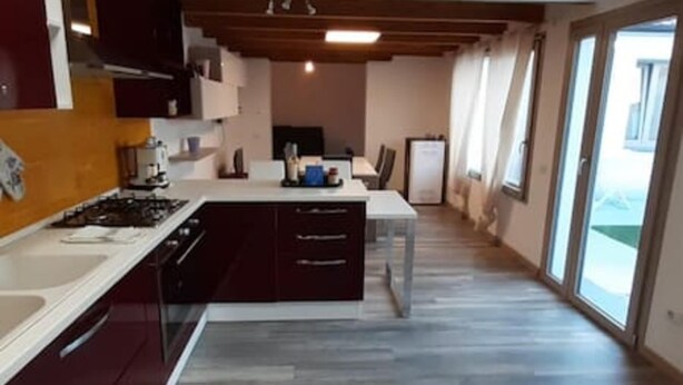 A modern kitchen with dark cabinetry, a white countertop, and a gas stove. - Casa Aida al Centro di Nurachi (Nurachi)