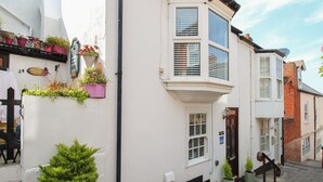 A corner building with a bay window, a small door, and a mailbox. - Little Gull Cottage (Weymouth)