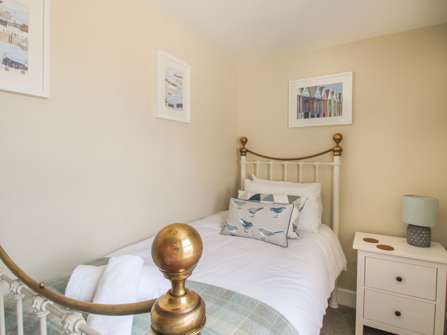 A neatly arranged bedroom with a bed, a bedside table, and a lamp.