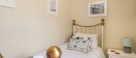 A neatly arranged bedroom with a bed, a bedside table, and a lamp.
