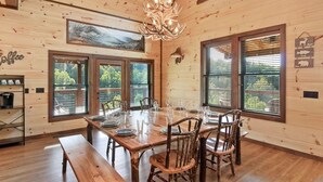 A wooden dining room with a large table set for six, surrounded by chairs. - Gorgeous 4BD w/ VIEWS! Theater +Firepit +Game Room (Sevierville)