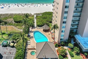 A hotel with a swimming pool, beach access, and a parking area. - Breath-Taking Beachfront Condo | Pool/Spa/Views (Marco Island)