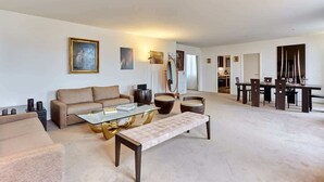 Amplia sala de estar con sofá, mesa de centro y comedor con mesa y sillas.
