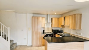 Una cucina moderna con mobili in legno, un piano di lavoro nero e un fornello in acciaio inossidabile.