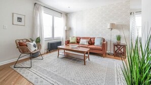 Una sala de estar moderna con un sofá, una mesa de centro y una alfombra estampada.