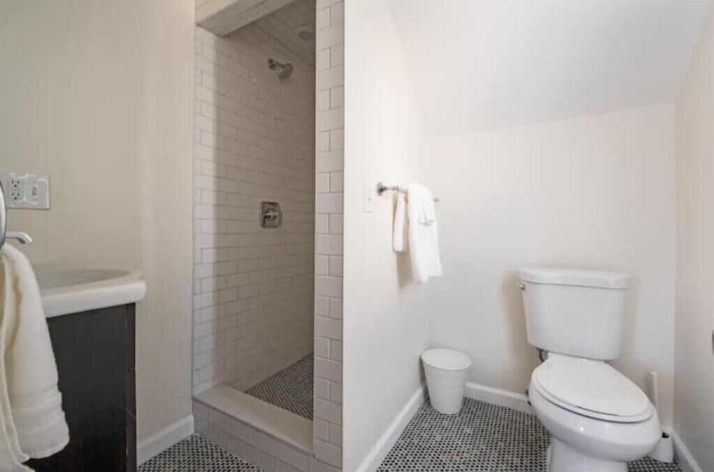 A bathroom with a shower, toilet, and sink.