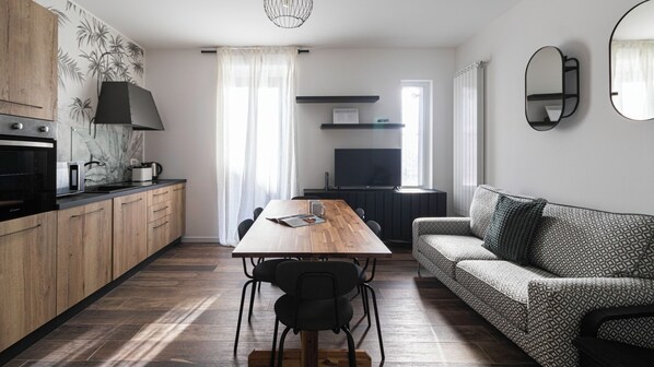 A modern kitchen with wooden cabinets, a dining table, and a sofa. - Italianway Comfort - Buenos Aires 65 E (Milan)