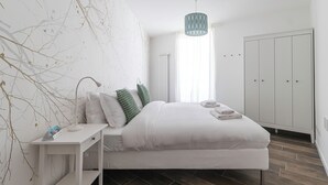 A modern bedroom with a large bed, a bedside table, a lamp, and a wardrobe. - Italianway Comfort - Buenos Aires 65 E (Milan)