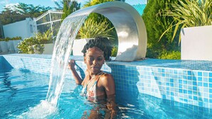 Una persona en una piscina con una fuente de agua.