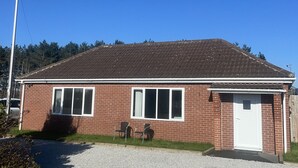 A single-story brick building with a garage, two windows, and a gravel driveway. - Beautiful 3-bed Bungalow in Bawtry Doncaster (Doncaster)