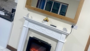 A living room with a white fireplace, a wooden mantel, and a mirror above it. - Beautiful 3-bed Bungalow in Bawtry Doncaster (Doncaster)