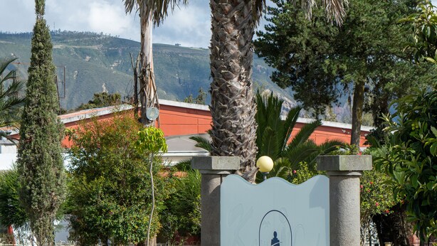 Une enseigne indiquant « LINDO Lodge », avec en arrière-plan un paysage montagneux.